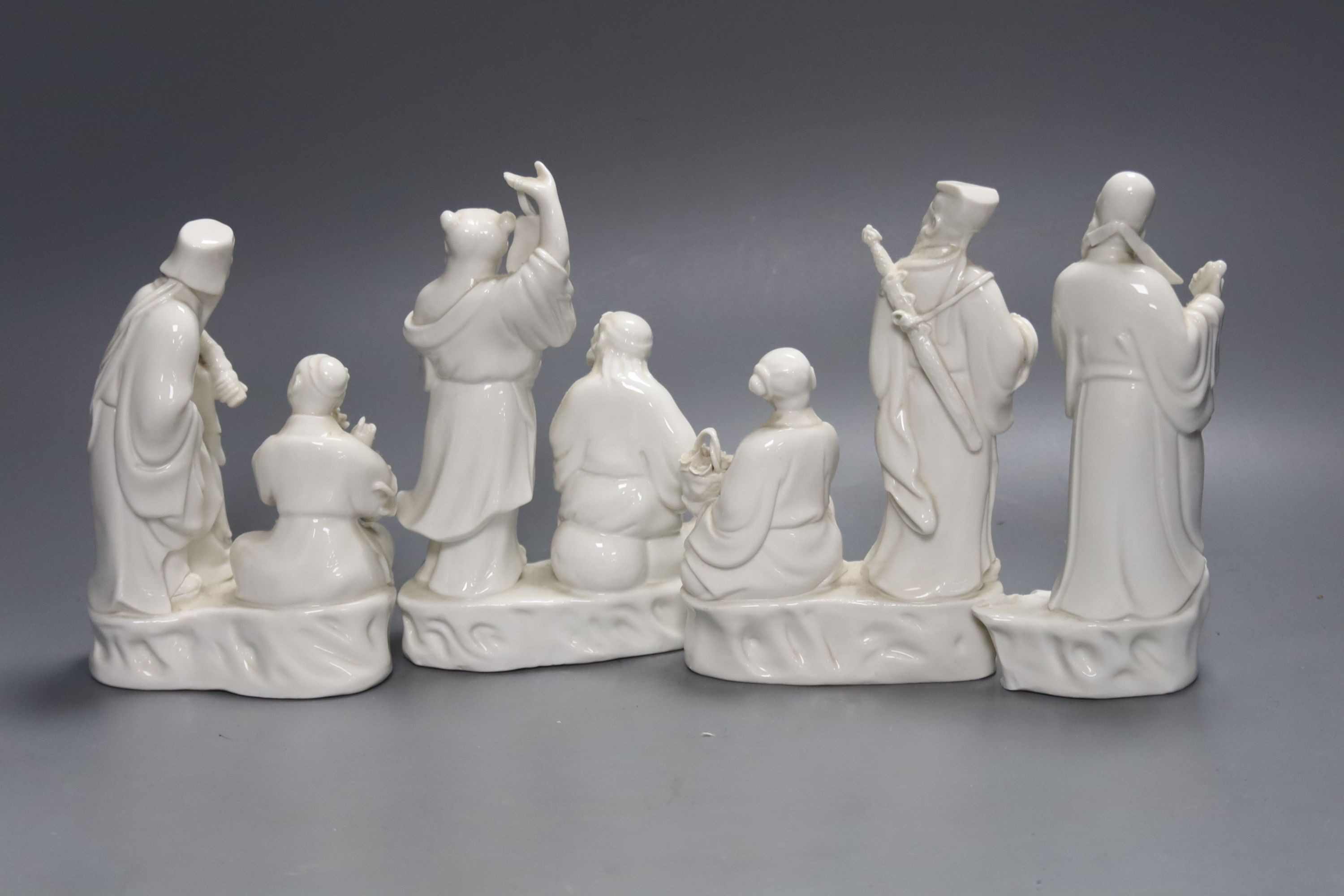 Three Chinese white porcelain groups of deities and a fragment, tallest 16cm